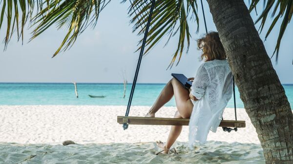 Девушка отдыхает на пляже на Мальдивах