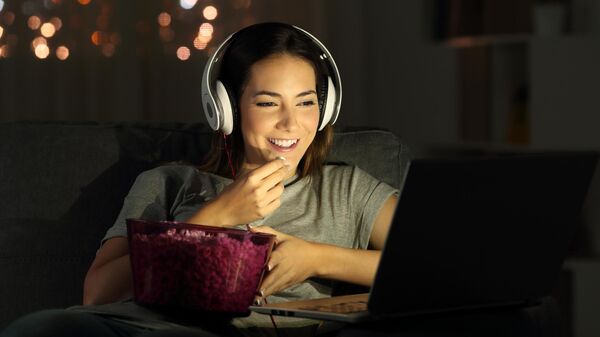Девушка смотрит комедию на ноутбуке