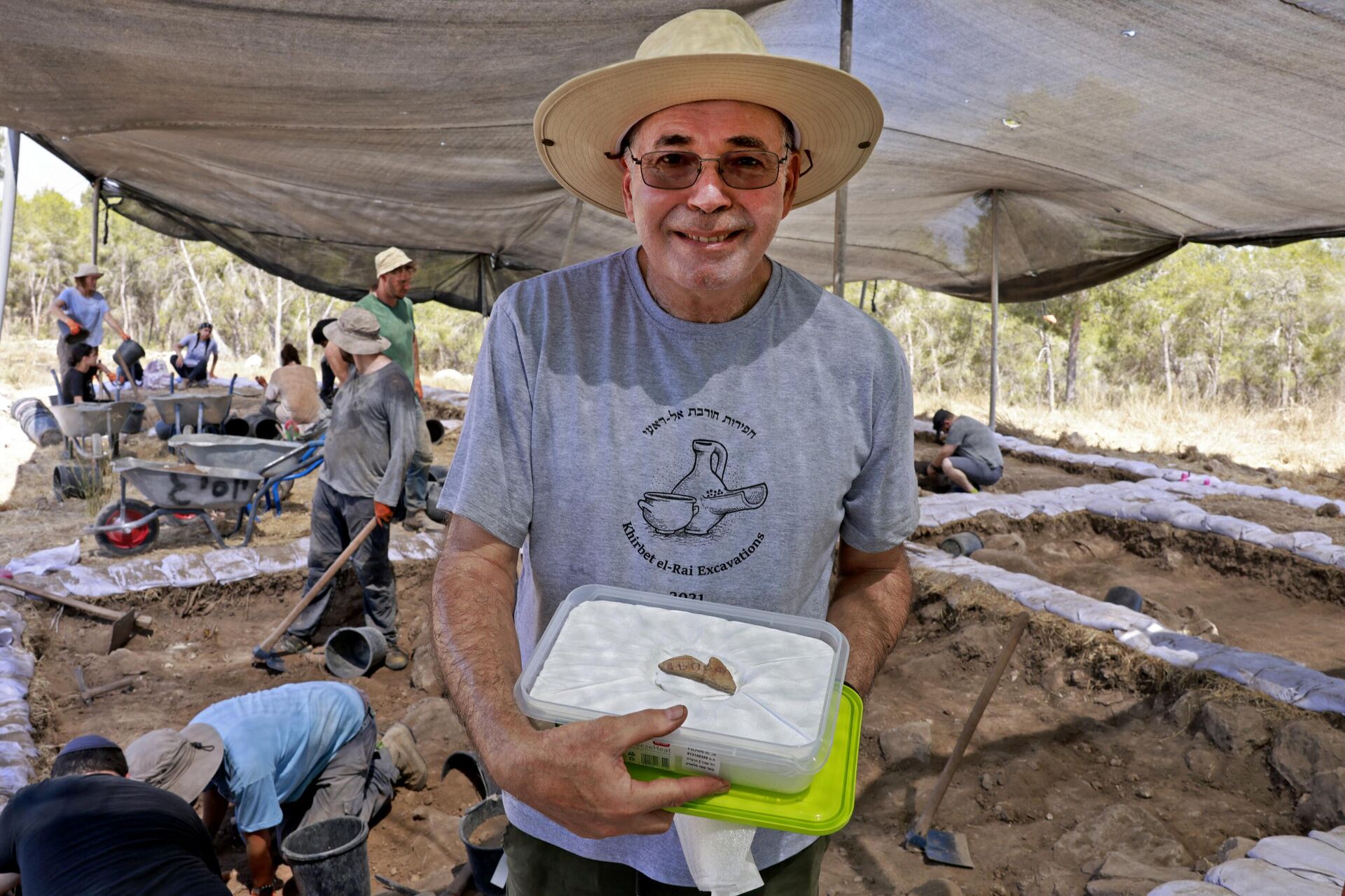Израильский археолог Йосеф Гарфинкель показывает фрагмент керамики возрастом 3100 лет с надписью на раскопках в Хирбат-эр-Раи - РИА Новости, 1920, 18.08.2023