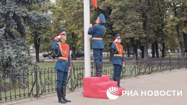Российский флаг в честь праздника торжественно подняли на одной из главных площадей Луганска