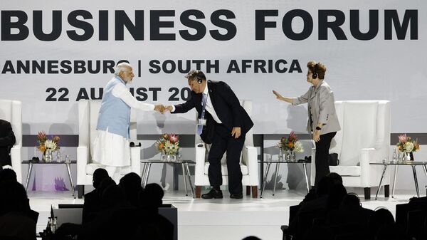 Премьер-министр Индии Нарендра Моди пожимает руку министру торговли Китая Ван Вэньтао на саммите БРИКС 2023 года в Конференц-центре Сэндтон в Йоханнесбурге