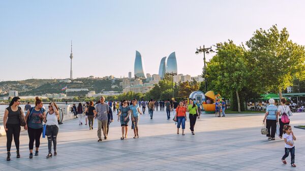 Туристы гуляют по набережной в Баку 