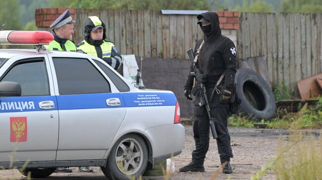 Сотрудники полиции в селе Куженкино Бологовского района Тверской области недалеко от места крушения самолета Embraer Legacy. 24 августа 2023