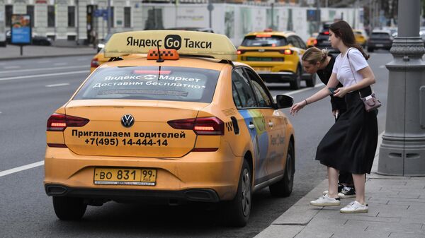 Девушки садятся в такси Яндекс Go на улице Москвы