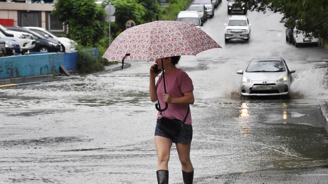 Девушка на одной из улиц, затопленных в результате сильного ливня