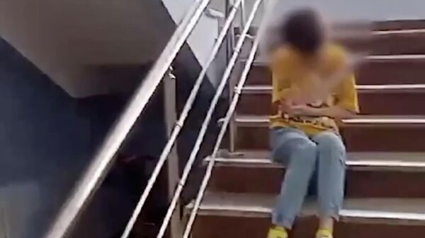 Кадр видео со спускающимся ползком по лестнице ребенком-инвалидом