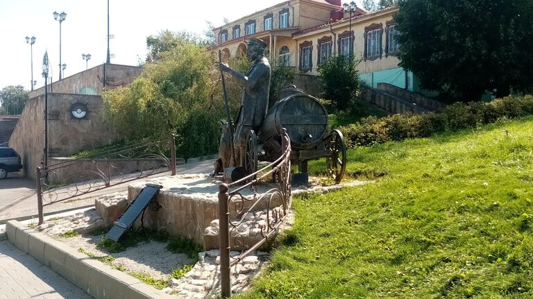 Памятник водовозу с другого ракурса. На заднем фоне — метки, до какого уровня и в какой год доходила вода при весеннем разливе реки, город Коломна