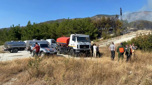 Волонтеры и автомобили на месте тушения лесного пожара в Геленджике