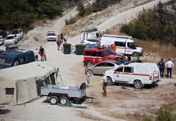 Волонтеры и автомобили МЧС на месте лагеря спасателей во время тушения лесного пожара в Геленджике