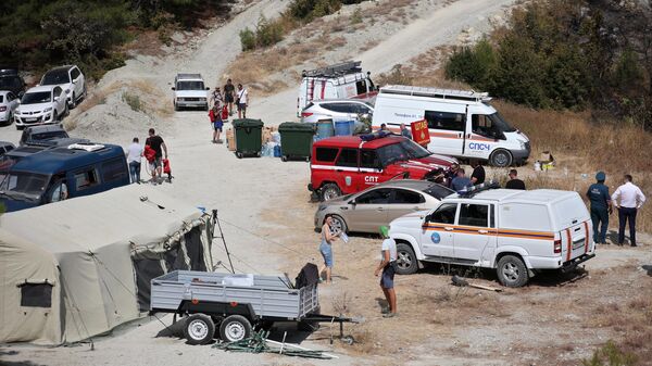 Волонтеры и автомобили МЧС на месте лагеря спасателей во время тушения лесного пожара в Геленджике