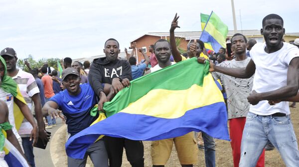 Жители Габона с национальными флагами в Либревиле