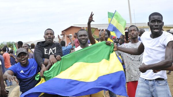 Мужчины с флагами Габона после объявления военными о перевороте в стране