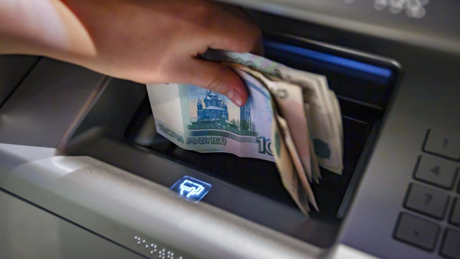 Посетитель кладет деньги на банковский счет в банкомат - РИА Новости, 1920, 30.04.2024