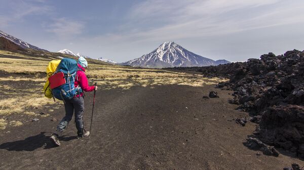 Турист идет к вулкану Ключевской на Камчатке 
