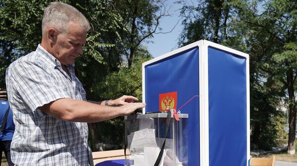 Избиратель во время досрочного голосования на выборах в ДНР в одном из дворов Мариуполя