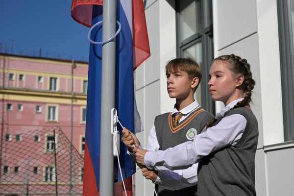Поднятие флага России на торжественной линейке, посвященной открытию новой средней школы №54 и началу учебного года в Новосибирске