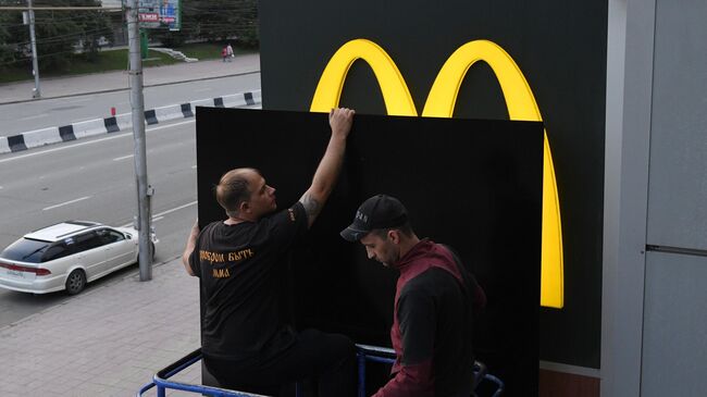 Закрытие вывески ресторана быстрого питания McDonald's на фасаде здания в Новосибирске 