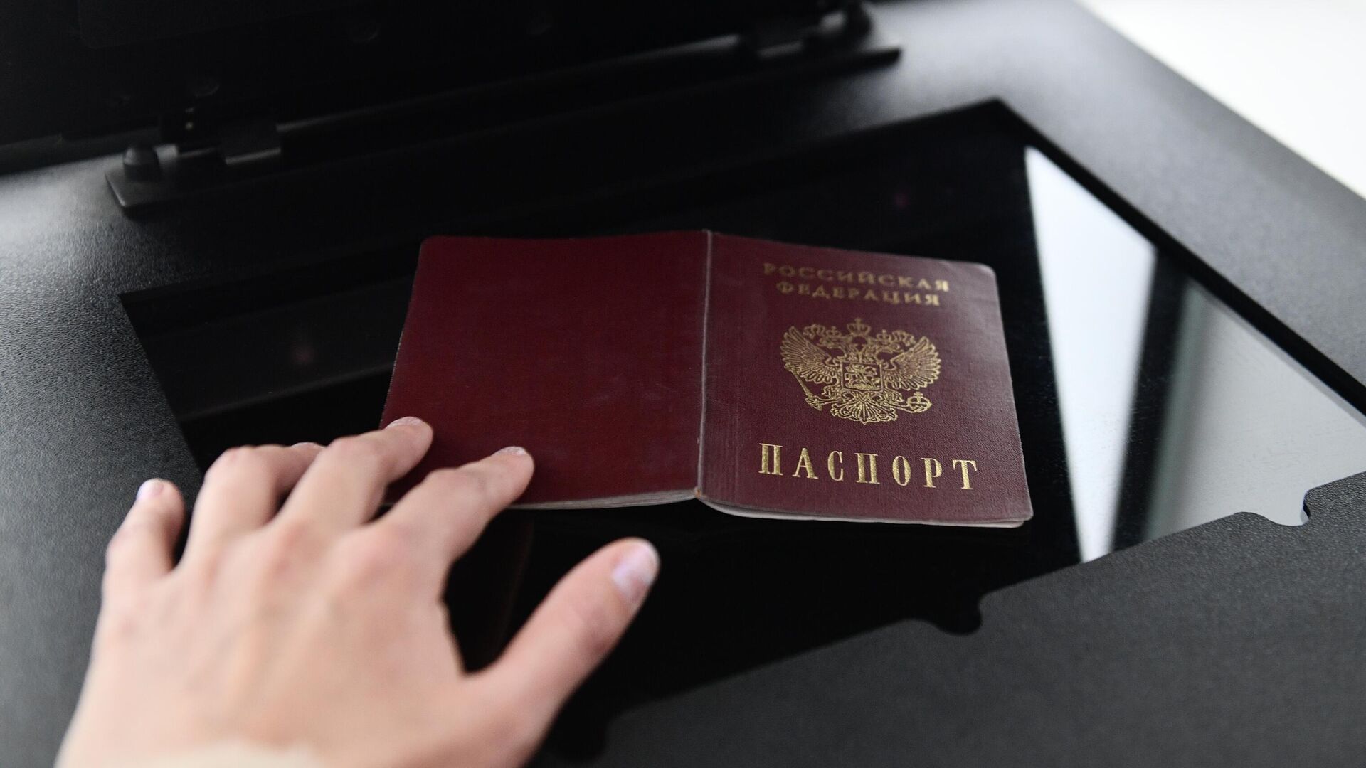 Девушка сканирует свой российский паспорт для оформления заграничного паспорта в специальной криптобиокабине в МФЦ в Екатеринбурге - РИА Новости, 1920, 17.11.2023