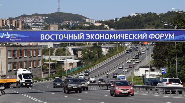 Баннер с символикой Восточного экономического форума у автомобильной трассы во Владивостоке