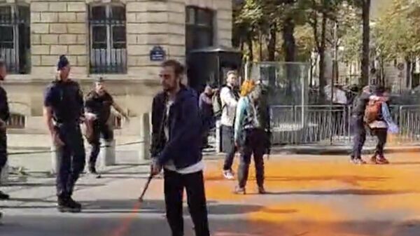Климатические активисты из организации Derniere Renovation обливают краской улицу напротив здания МВД в Париже