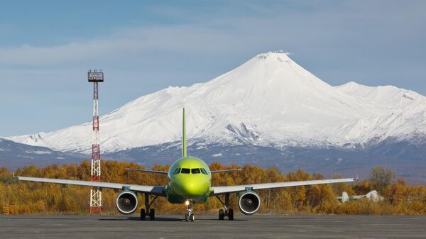 Самолет Airbus А-320  в международном аэропорту Елизово. На дальнем плане - Авачинский вулкан
