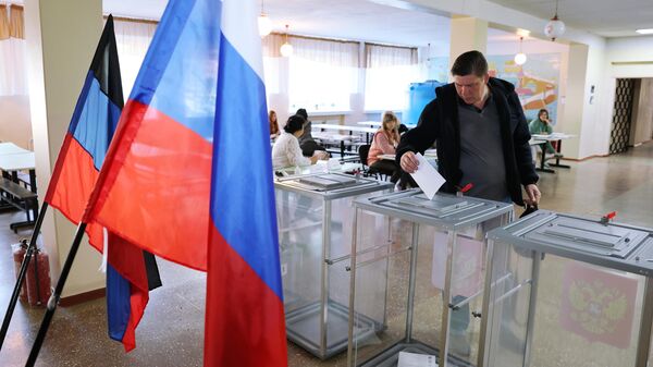 Мужчина голосует на выборах в парламент и органы самоуправления в Единый день голосования на одном из избирательных участков в Донецке