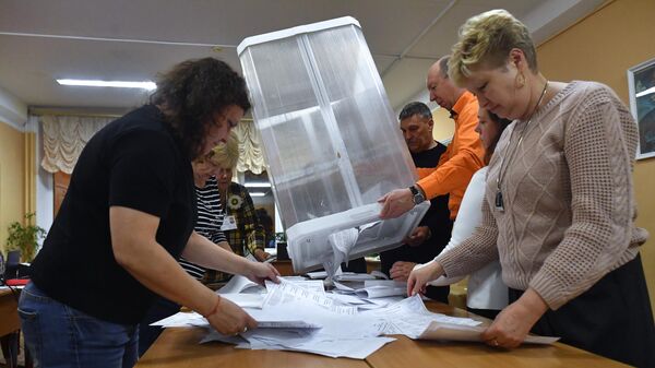 Члены участковой избирательной комиссии сортируют и считают бюллетени после окончания процедуры голосования на выборах мэра Москвы на избирательном участке в Москве
