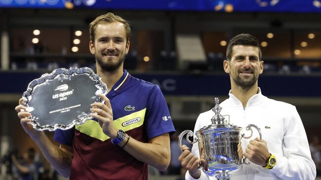 Даниил Медведев (слева) и Новак Джокович с трофеями US Open