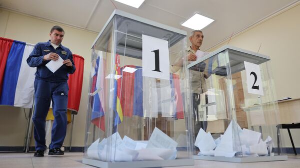 Мужчины голосуют на выборах депутатов Государственной думы России на избирательном участке № 521 в поселке Донское Калининградской области