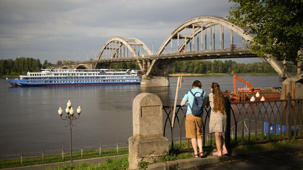 Туристы на набережной Рыбинска на фоне моста через Волгу, Ярославская область