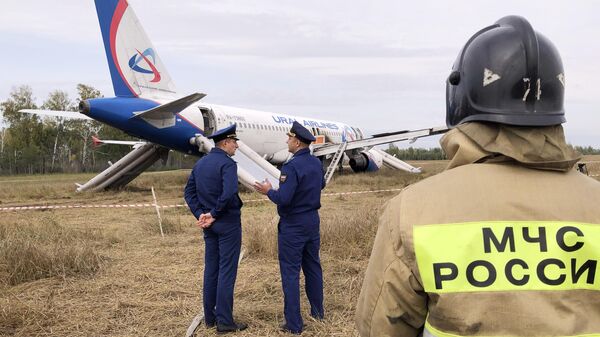 Сотрудники спасательных служб на месте аварийной посадки самолета авиакомпании Уральские авиалинии на грунт в Убинском районе Новосибирской области