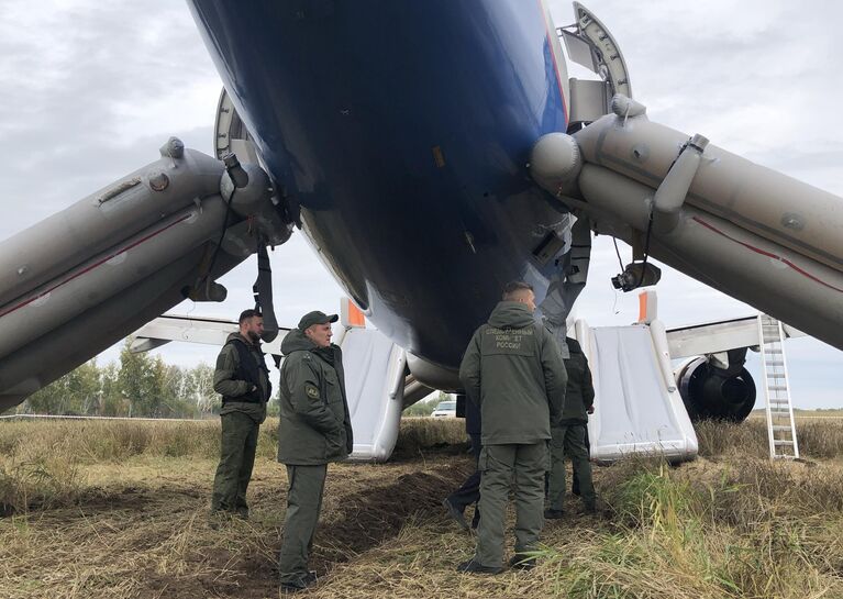 Сотрудники СК РФ возле самолета авиакомпании Уральские авиалинии, совершившего аварийную посадку на грунт в Убинском районе Новосибирской области