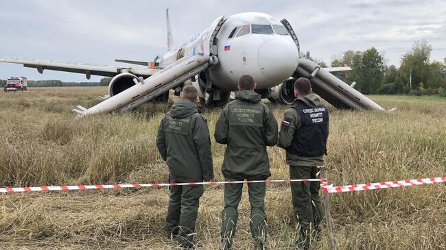 Сотрудники СК РФ возле самолета авиакомпании Уральские авиалинии, совершившего аварийную посадку на грунт в Убинском районе Новосибирской области