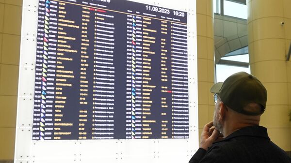 Пассажир возле электронного табло вылетов в аэропорту Домодедово в Москве