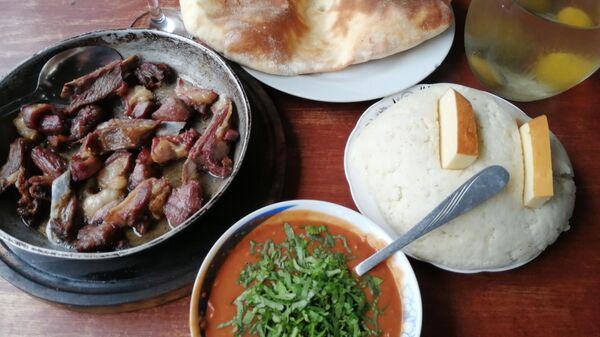 Аутентичный обед в абхазской апацхе копченое мясо, фасоль, мамалыга с сыром, лаваш
