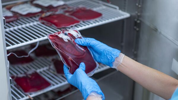 Врач проверяет пакеты с донорской кровью в лаборатории