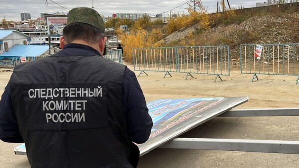 Сотрудник СК России на месте падения рекламного щита в Якутске
