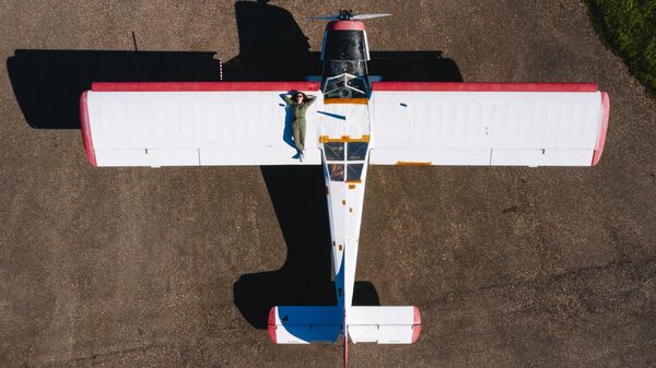 Туристка позирует на крыле самолета в Старицком аэроклубе