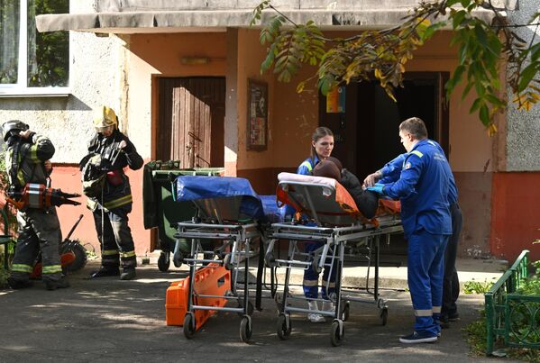 Сотрудники скорой медицинской помощи с пострадавшей на месте взрыва газа в жилом доме в подмосковной Балашихе