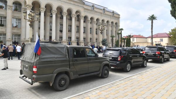 Колонна автомобиле у здания администрации в городе Евлах во время встречи представителей Азербайджана и армян Нагорного Карабаха