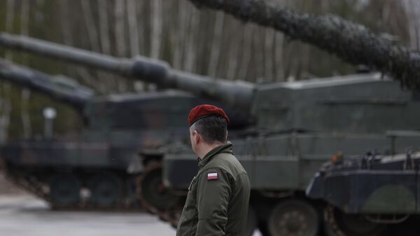 Польский военный рядом с танками Leoapard 2 во время учений в рамках военной помощи ЕС Украине