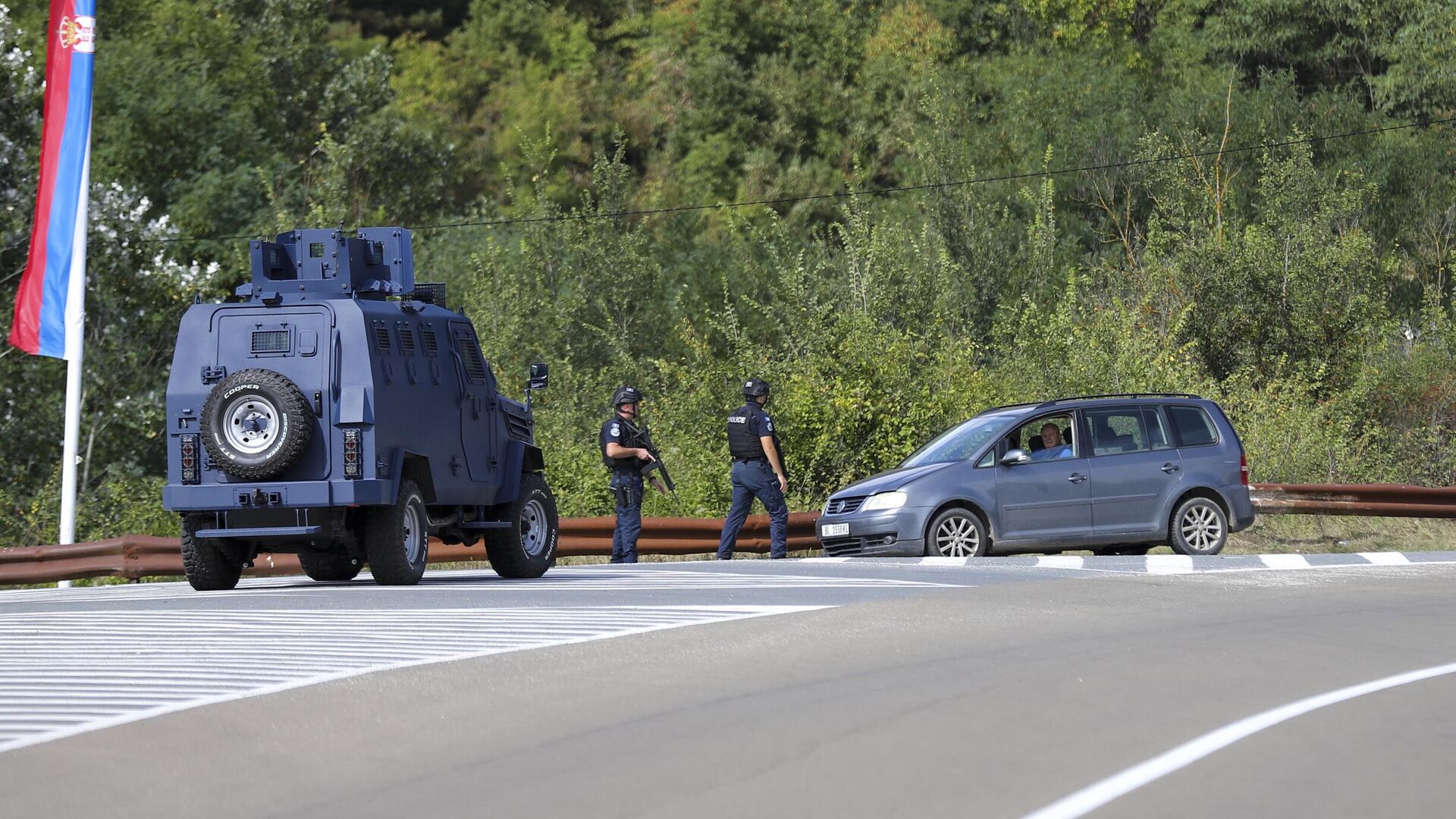 Офицеры косовской полиции охраняют дорогу возле деревни Баньска, северное Косово. 24 сентября 2023 - РИА Новости, 1920, 24.09.2023