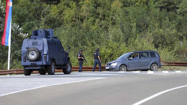 Офицеры косовской полиции охраняют дорогу возле деревни Баньска, северное Косово. 24 сентября 2023