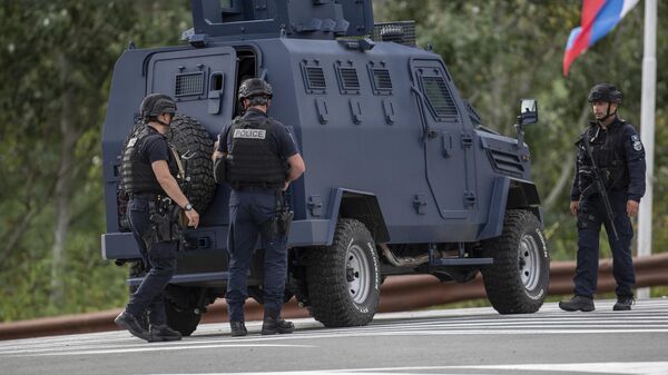 Офицеры полиции Косово охраняют перекресток дороги, ведущей к монастырю Баньска