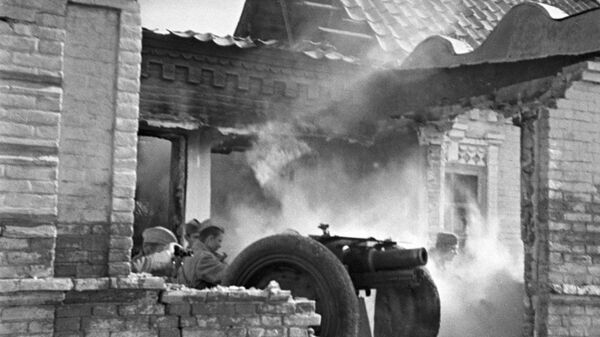 Южный фронт (с 20 октября 1943 — 4-й Украинский фронт). Советские артиллеристы бьют прямой наводкой по засевшим в соседних зданиях немцам,  уличные бой в Мелитополе. Октябрь, 1943 года