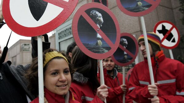 Активисты держат плакаты против применения ядерного оружия перед посольством США в Сантьяго