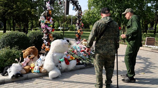Люди в Донецке несут цветы к мемориалу в память о детях, погибших из-за обстрелов Донбасса вооруженными силами Украины