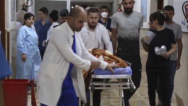 Медицинский персонал доставляет раненого в больницу в Хамдании, провинция Найнава, Ирак