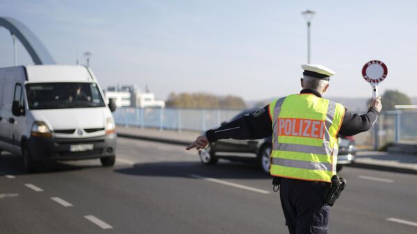 Сотрудник полиции останавливает автомобиль на границе Польши и Германии