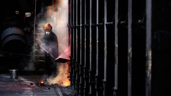 Рабочий у коксовой батареи на металлургическом заводе Уральская сталь в Новотроицке Оренбургской области